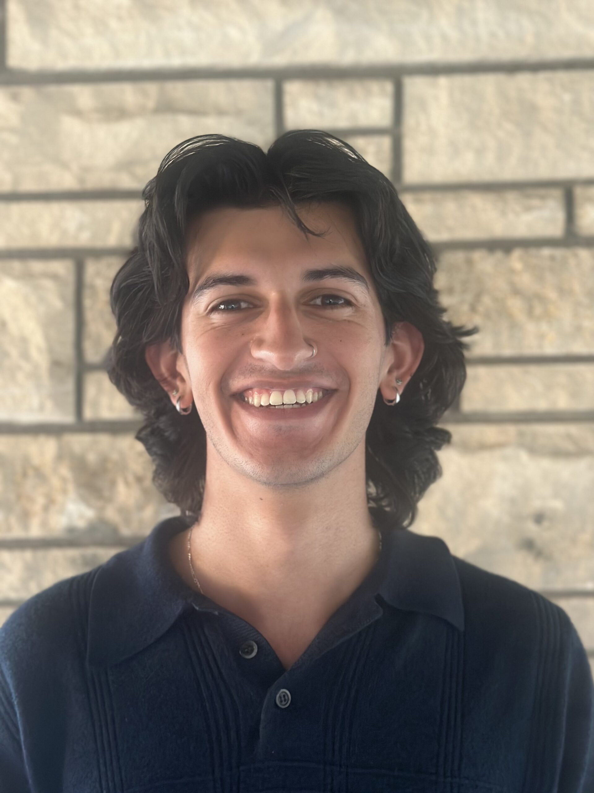 Tobias standing next to a brick wall.