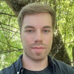 Shawn outside in front of a tree.