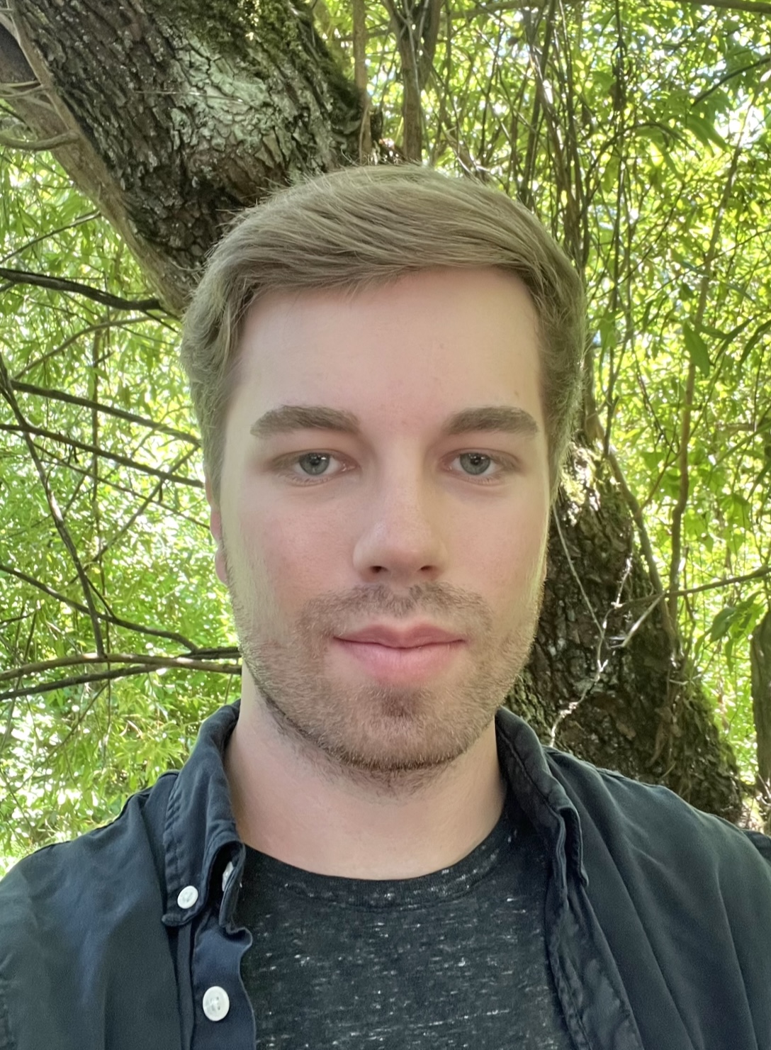 Shawn outside in front of a tree.