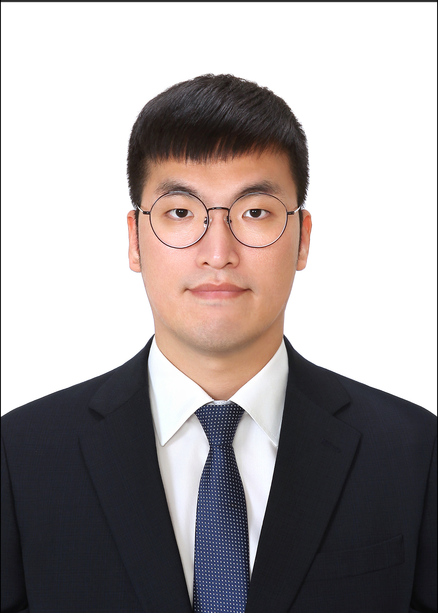 Juyoung in front of a white wall, wearing a suit.