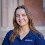 Mirina standing outside in a blue t-shirt.