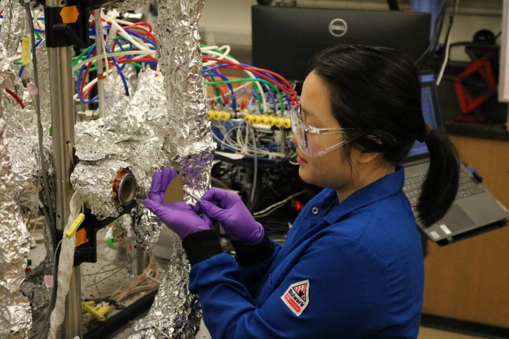 A student works with a silicon wafer by a molecular layer deposition reactor.